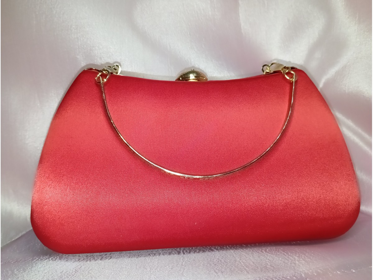 Back side of red satin clutch with smooth finish and gold frame