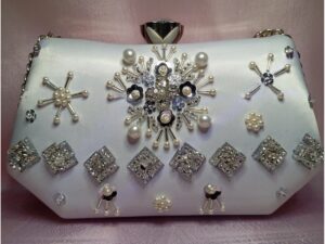 Front view of white crystal clutch for women with pearl and rhinestone floral embellishments